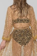 Woman wearing a golden beachwear dress